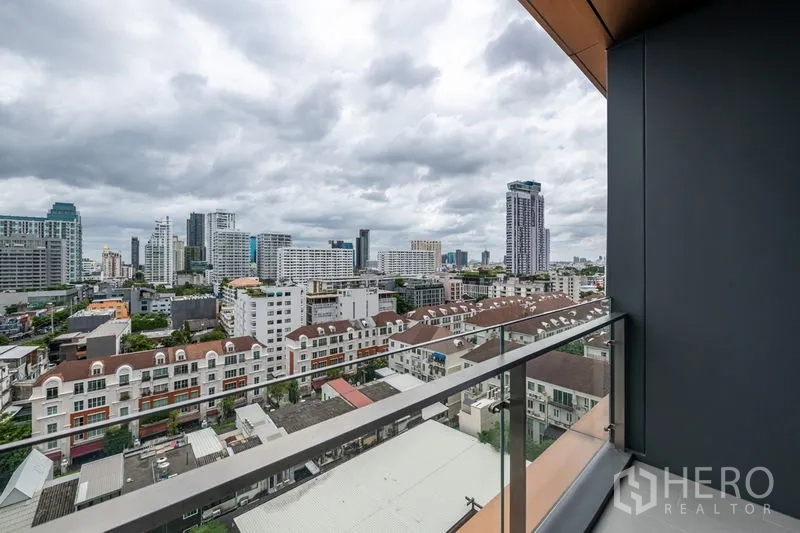 公寓 出租在Watthana, Bangkok - 私人阳台玻璃护栏，俯瞰曼谷城市天际线。