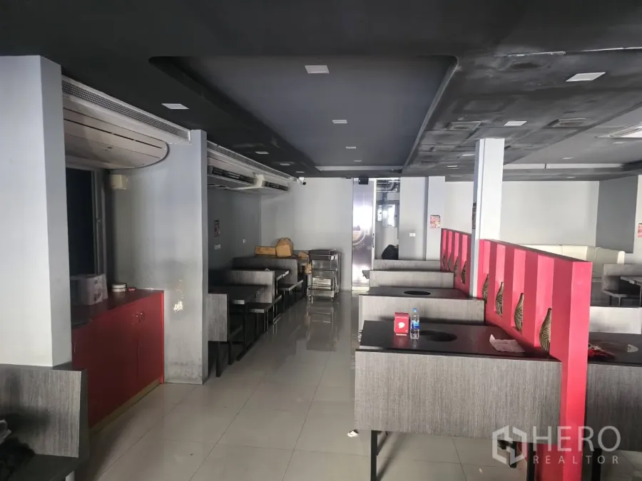 零售空间 出租在Khlong Toei, Bangkok - 开放式零售室内，卡座、红色隔断、瓷砖地面与深色吊顶，位于คลองเตย。
