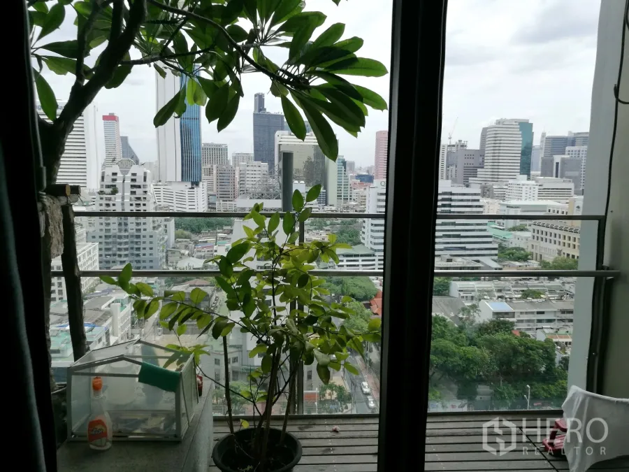 Condominium for rent or sale in Sathon, Bangkok - High-floor balcony with potted plants overlooking the Bangkok skyline in Sathon.