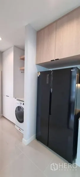 Detached House for rent in Saphan Sung, Bangkok - Modern pantry with tall black refrigerator and overhead storage cabinets.