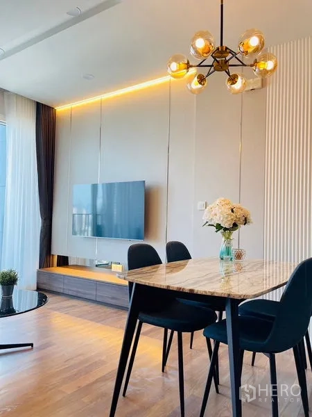 Condominium for rent in Khlong Toei, Bangkok - Contemporary bathroom with glass-enclosed rain shower, white vanity and light ceramic tiles.