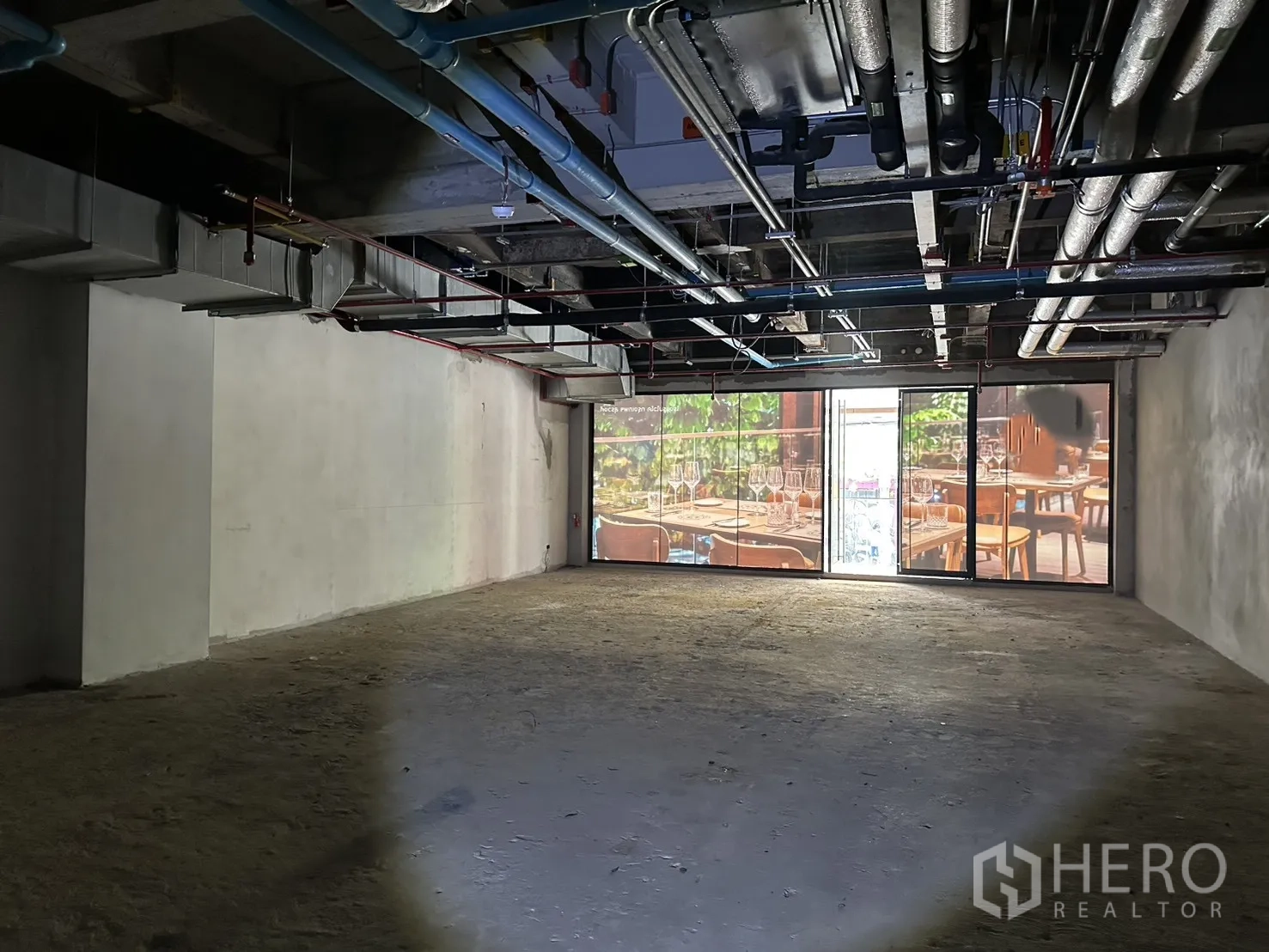 零售空间 for rent in Bang Rak, Bangkok - 整面玻璃门面与推拉门，为空置空间引入采光。