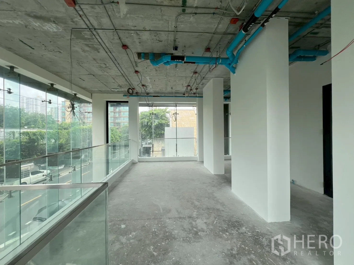 Retail Space for rent - Long mezzanine walkway with columns and panoramic glazing above the street.