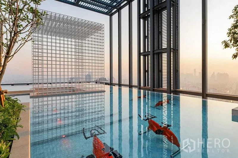 Condominium for rent in Ratchathewi, Bangkok - Sky pool with underwater exercise bikes and sculptural cube, city panorama.