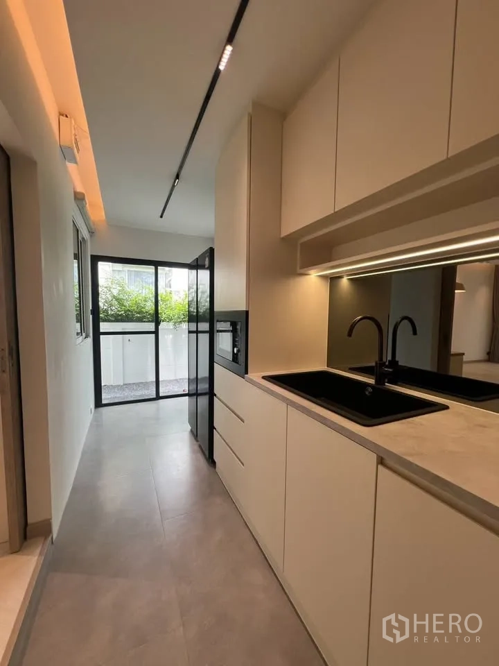 联排别墅 for rent in Prawet, Bangkok - 厨房走廊通向推拉玻璃门与露台。