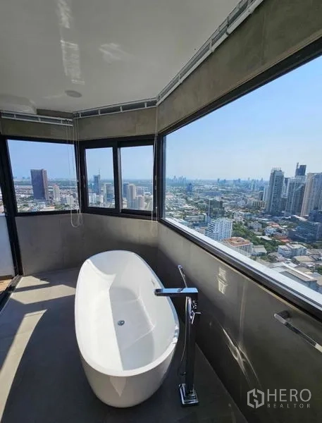 Condominium for rent or sale - Daytime tub room with wraparound windows and city panorama.