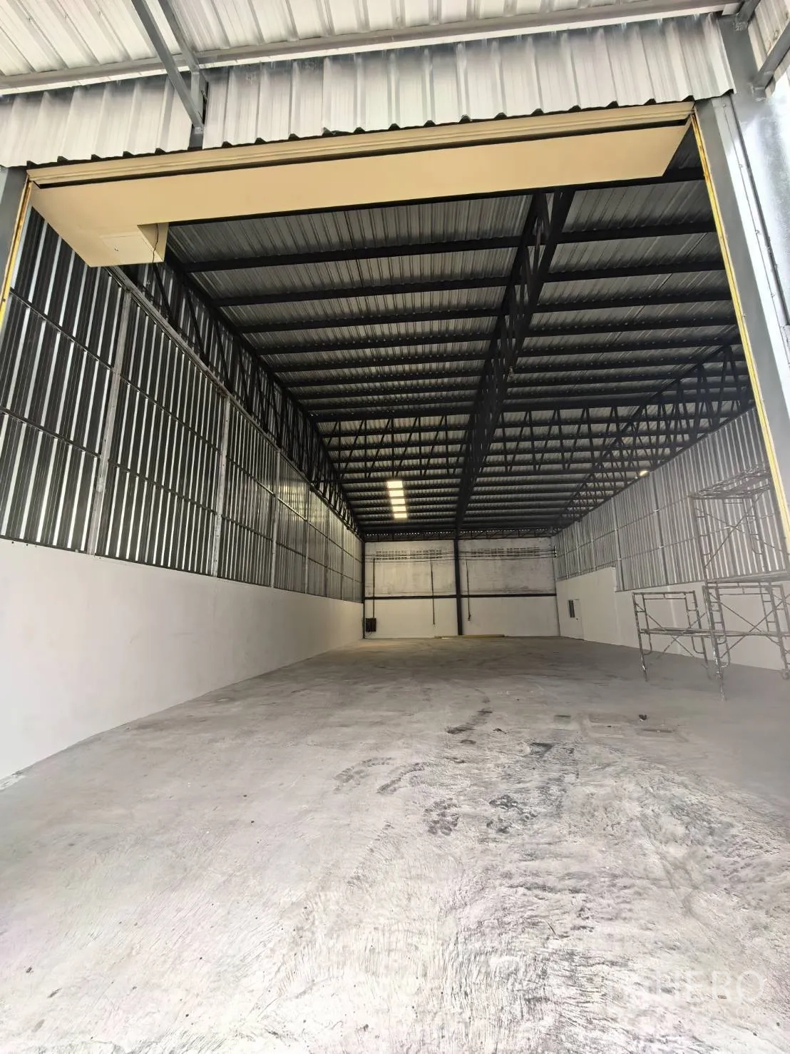 โกดัง for rent in Suan Luang, Bangkok - มุมมองจากปากทางเข้าไปยังโกดังโล่ง พื้นคอนกรีตและโครงหลังคาเหล็กสูง.
