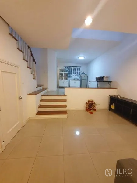 Townhouse for sale in Bang Kapi, Bangkok - Split-level dining and kitchen zone with tiled floor and storage units.