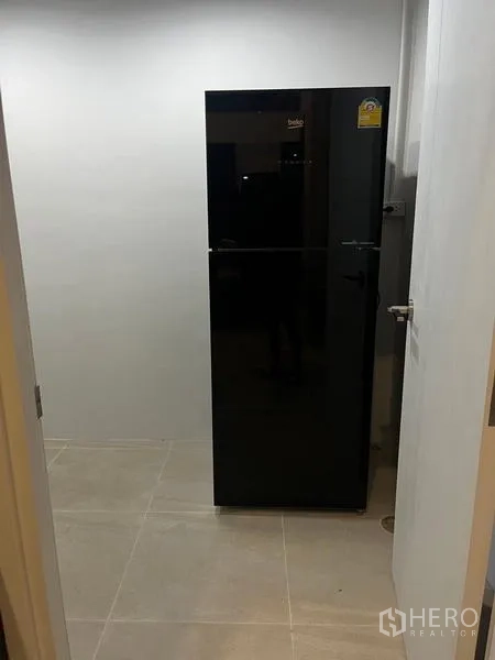 Townhouse for rent - Utility room with a sleek black refrigerator.