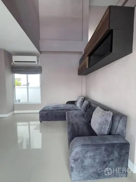 บ้านเดี่ยว for rent or sale in Saphan Sung, Bangkok - มุมมองอีกด้านของห้องนั่งเล่นกับโซฟาตัวใหญ่สีเทา.