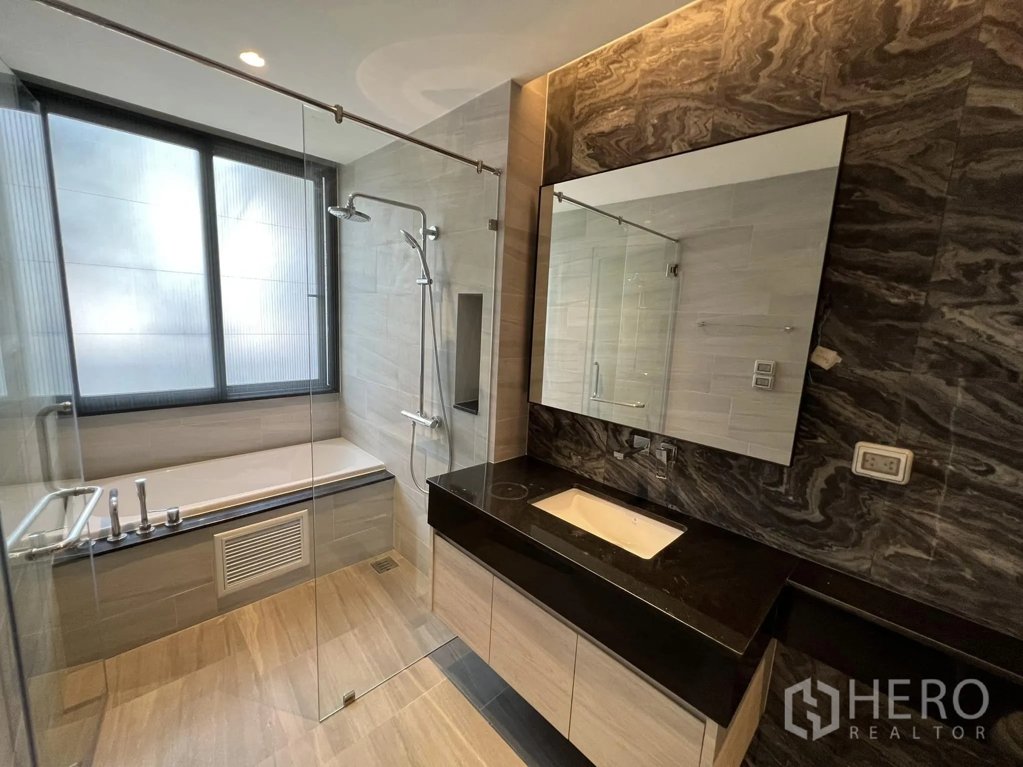 Detached House for rent or sale in Yan Nawa, Bangkok - Modern bathroom with bathtub, glass shower and stone accents.