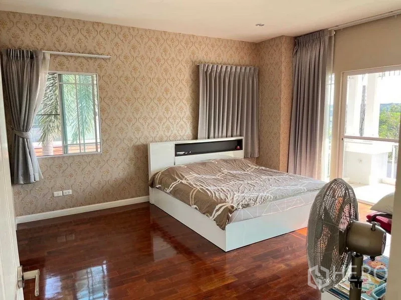 บ้าน ขายในSamut Prakan - ห้องนอนใหญ่พื้นไม้ ผนังวอลล์เปเปอร์ มีหน้าต่างบานใหญ่และประตูออกสู่ระเบียง