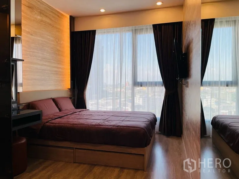 คอนโด ให้เช่าในBang Na, Bangkok - ห้องนอนหลัก เตียงขนาดใหญ่ แสงไฟอบอุ่น และหน้าต่างสูงมองเห็นวิวเมือง