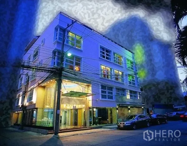 Retail Space for rent - Modern low-rise corner building at night with wide glass frontage and curbside parking.