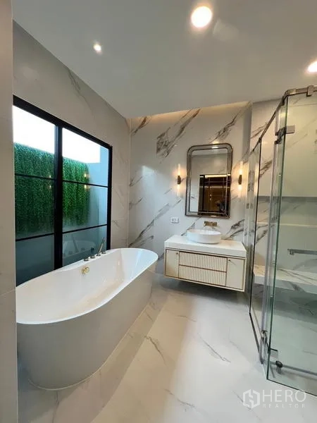 Detached House for rent or sale in Saphan Sung, Bangkok - Luxury bathroom featuring a freestanding bathtub, glass shower and marble-look walls.