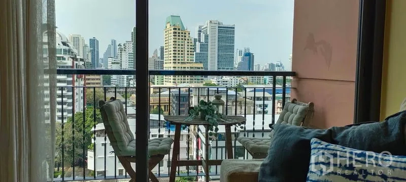 Condominium for rent or sale in Khlong Toei, Bangkok - Private balcony with bistro set and city skyline view of Sukhumvit.