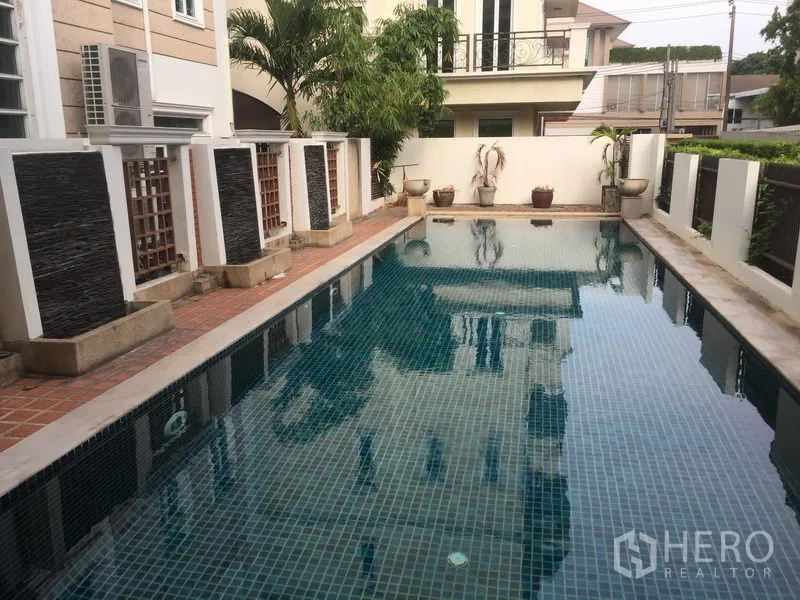 联排别墅 出售在Huai Khwang, Bangkok - 联排别墅旁的公共泳池，铺砖池岸与私密围墙。