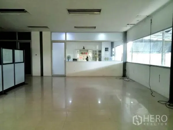 工厂 出租在Bang Phli, Samut Prakan - 明亮的办公室或接待区，带大窗、玻璃门和抛光瓷砖地面。