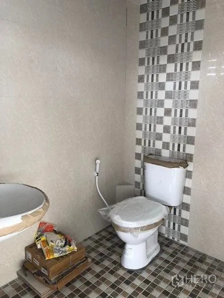 货栈 出租在Pathum Thani - 干净的瓷砖卫生间，坐便器、喷枪和花纹墙面