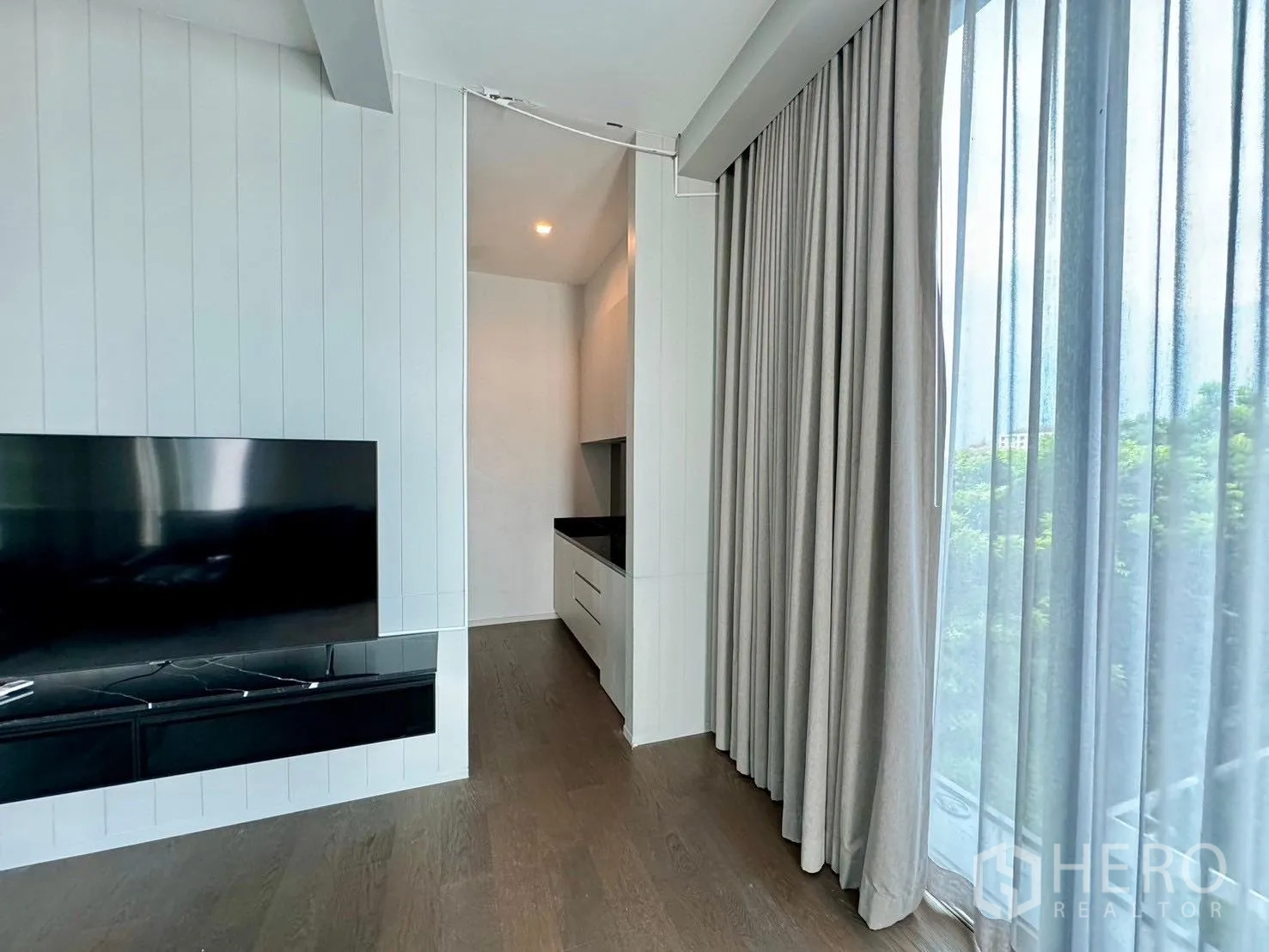 独立式住宅 出租或出售在Prawet, Bangkok - 电视墙与落地窗纱帘的明亮一角。