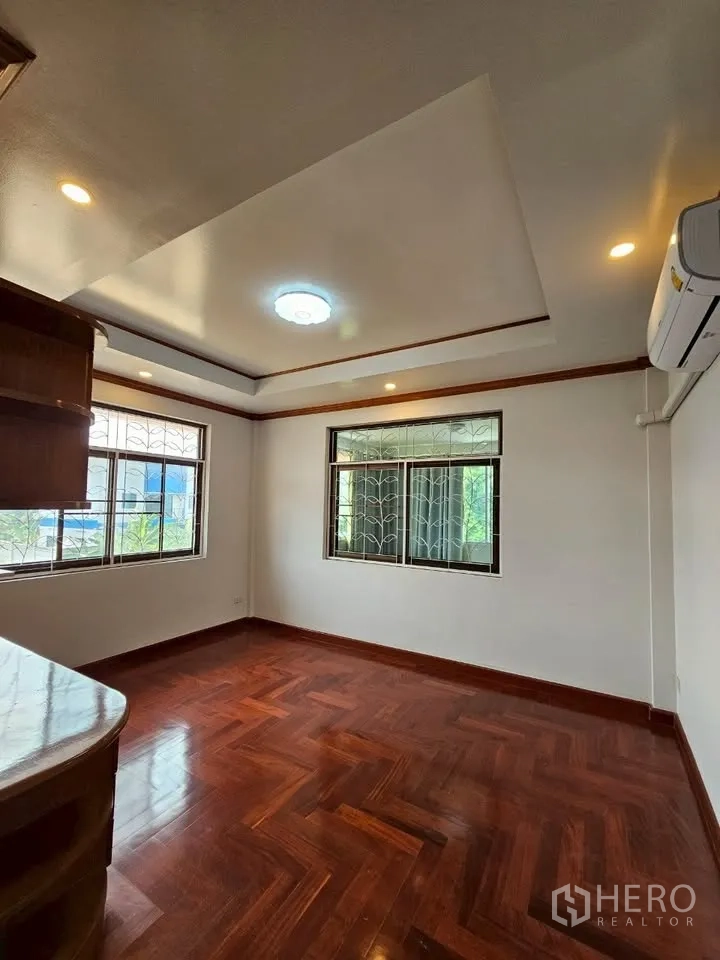 带办公室的家 for rent in Wang Thonglang, Bangkok - 明亮房间，木地板、空调与转角窗，适合办公布置。