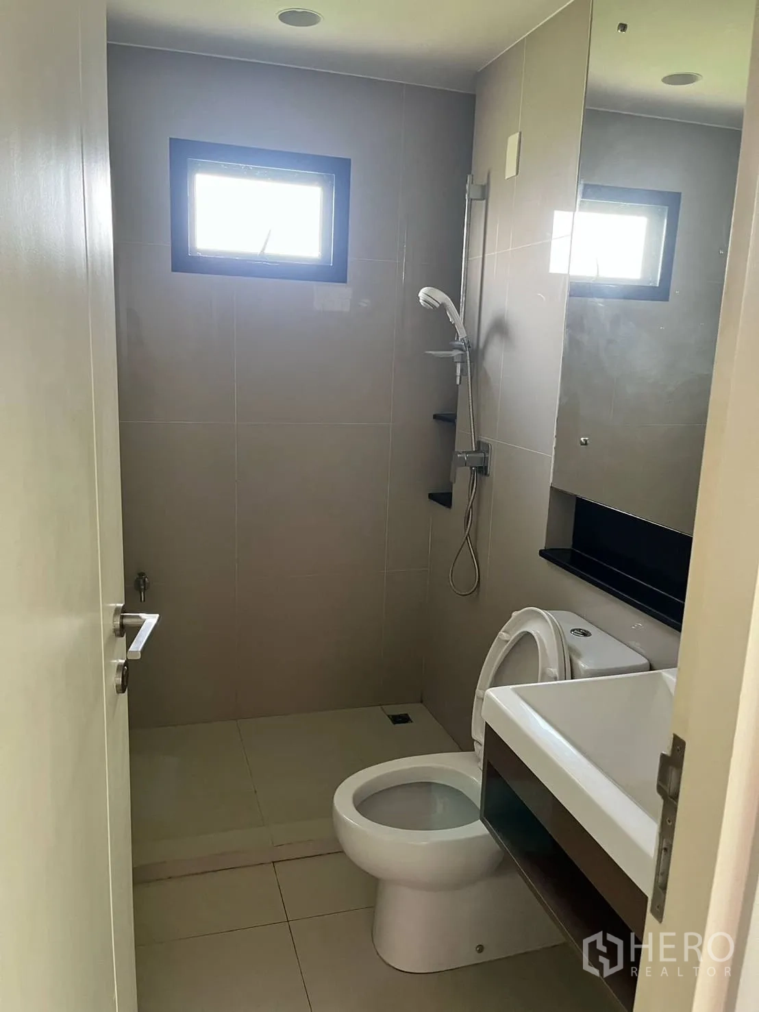 Detached House for rent or sale in Lam Luk Ka, Pathum Thani - Compact bathroom with walk‑in shower, wall mirror and small window.