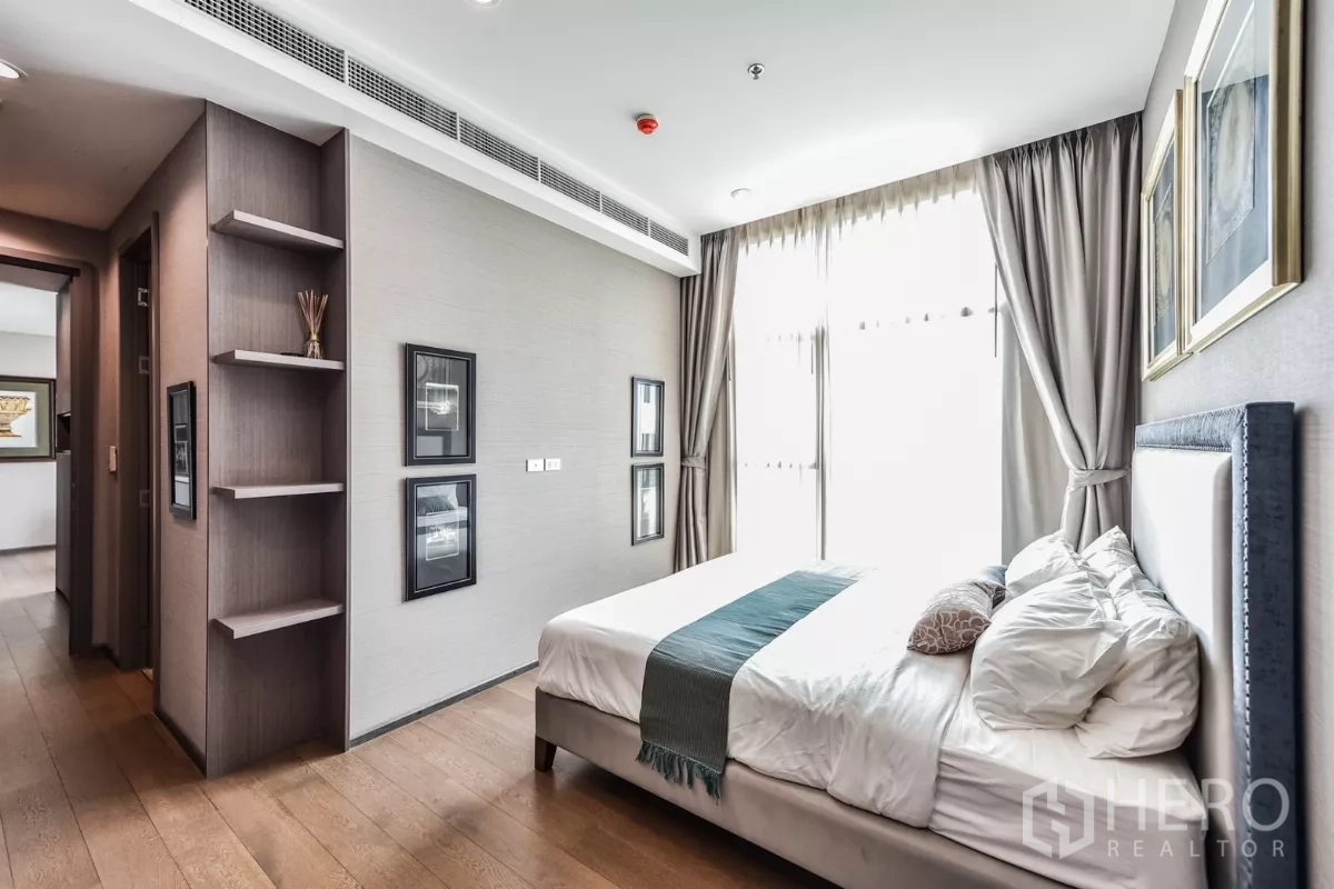 公寓 出租或出售在Bang Rak, Bangkok - 卧室视角展示大床、垂挂高窗帘与装饰画框。
