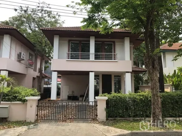 Detached House for sale in Wang Thonglang, Bangkok - Two-storey detached house with balcony, gated carport, and mature trees at the front.