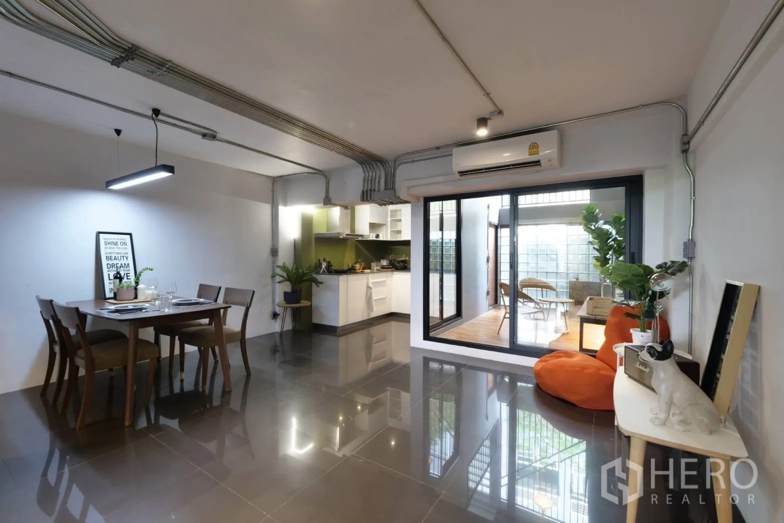 联排别墅 出租在Khlong Toei, Bangkok - 开放式餐厨区，推拉玻璃门通木平台露台。
