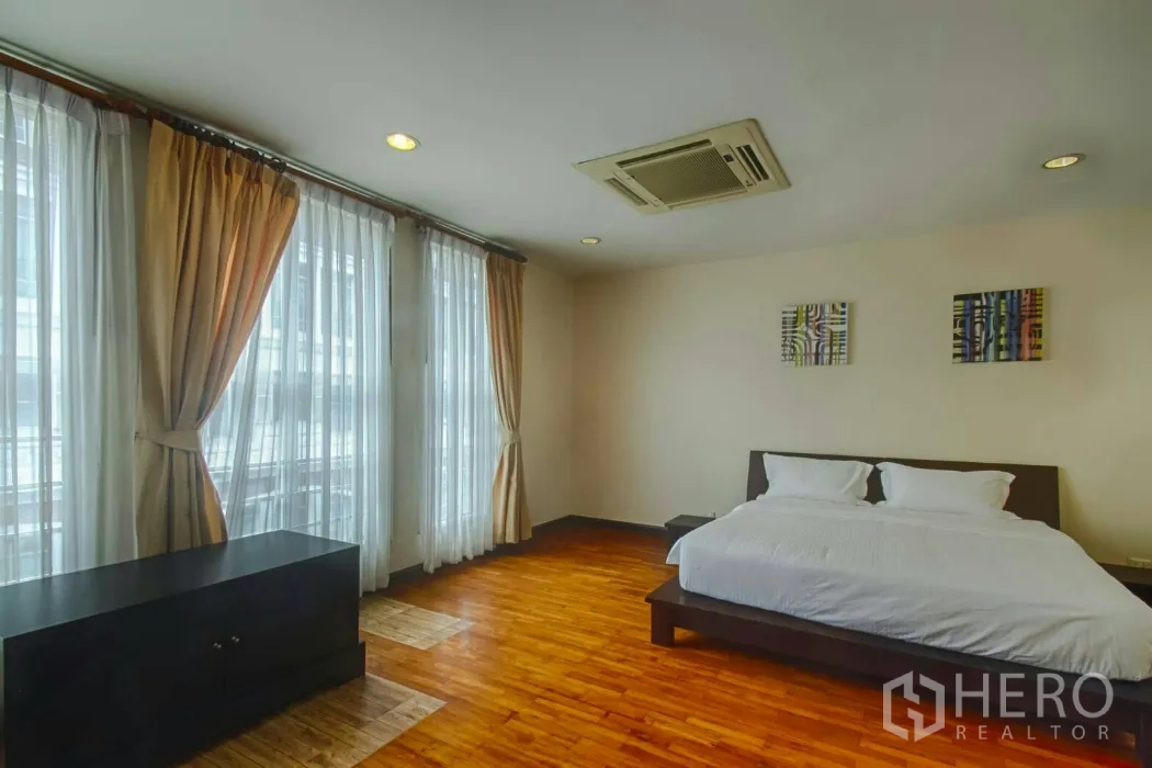 ทาวน์เฮาส์ ให้เช่าในWatthana, Bangkok - ห้องนอนสว่างด้วยหน้าต่างเต็มผนัง ผ้าม่านโปร่ง และพื้นไม้