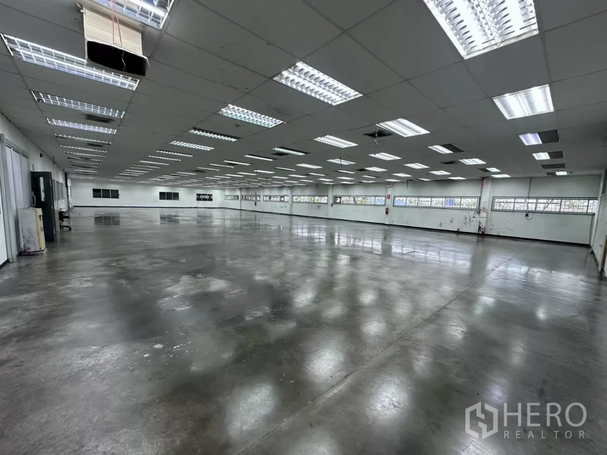 工厂 出售在Lat Krabang, Bangkok - 宽阔制造区域，反光地面与成排日光灯。