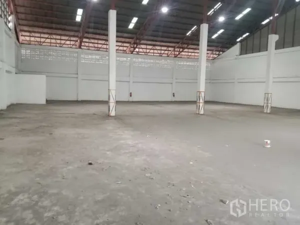Factory for rent in Samut Prakan - Spacious warehouse interior with columns and durable concrete floor.