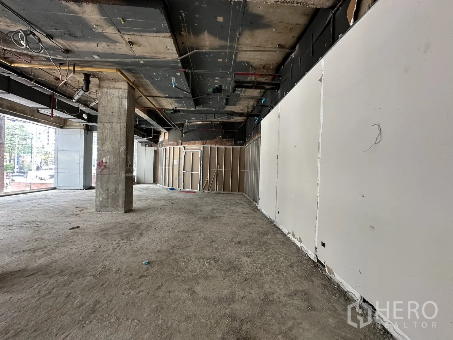 零售空间 for rent in Watthana, Bangkok - 宽敞未装修空间，白色隔墙与整面落地窗观街景。
