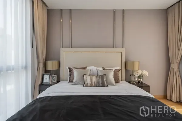 Detached House for rent or sale in Yan Nawa, Bangkok - Primary bedroom with upholstered headboard, soft drapes and bedside tables.