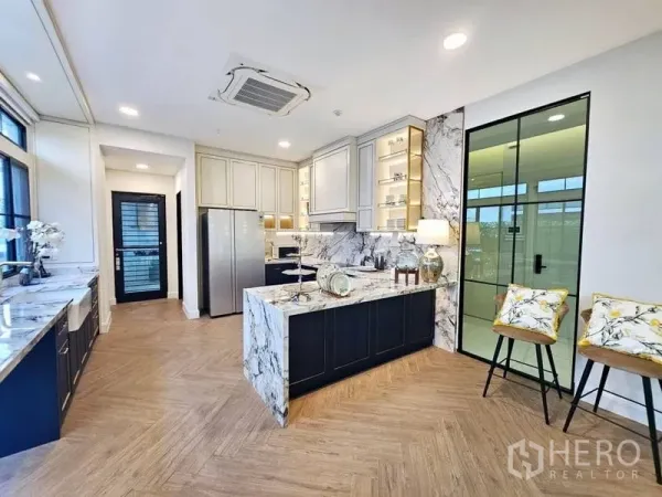Detached House for rent or sale in Saphan Sung, Bangkok - Modern marble kitchen with island, full-height cabinetry and herringbone wood floor in a Saphan Sung home.