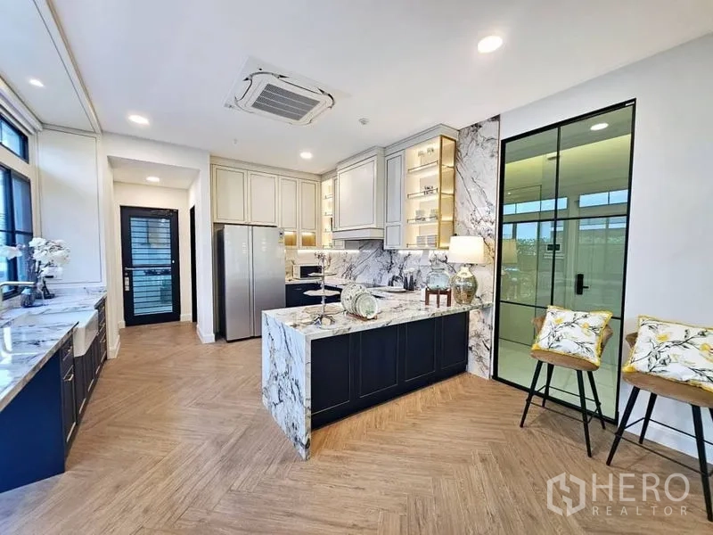 Detached House for rent or sale in Saphan Sung, Bangkok - Modern marble kitchen with island, full-height cabinetry and herringbone wood floor in a Saphan Sung home.
