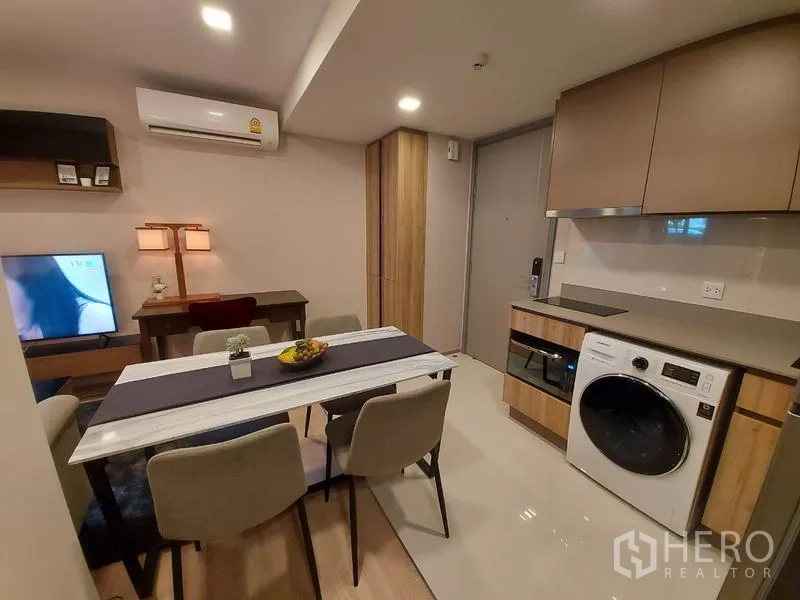 公寓 出租或出售在Watthana, Bangkok - 餐区邻近一体化厨房，设电视柜与台下洗烘机。