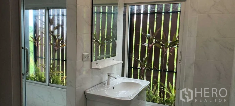 Townhouse for rent or sale in Saphan Sung, Bangkok - Contemporary bathroom with vanity, large window and garden view.