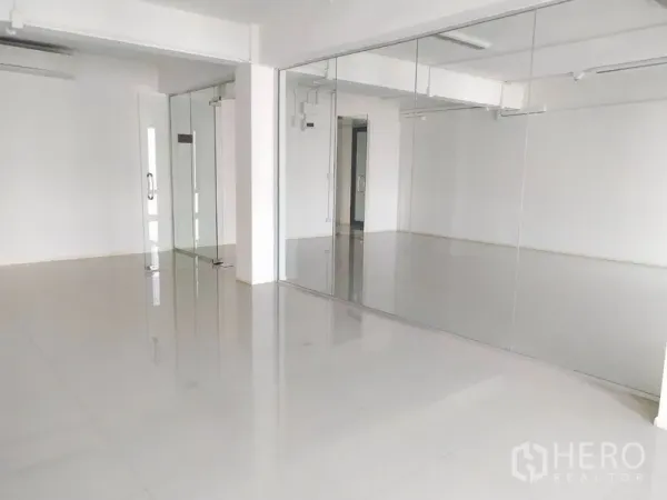 办公空间 出租在Bang Na, Bangkok - 开放式办公室，推拉玻璃门与白色墙面。