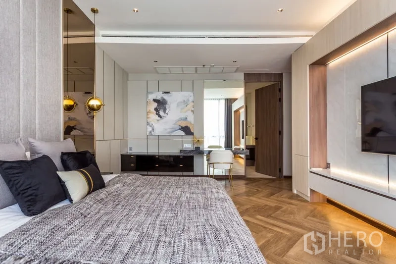 Condominium for rent in Khlong Toei, Bangkok - Spacious master bedroom with TV wall, custom paneling and study area.