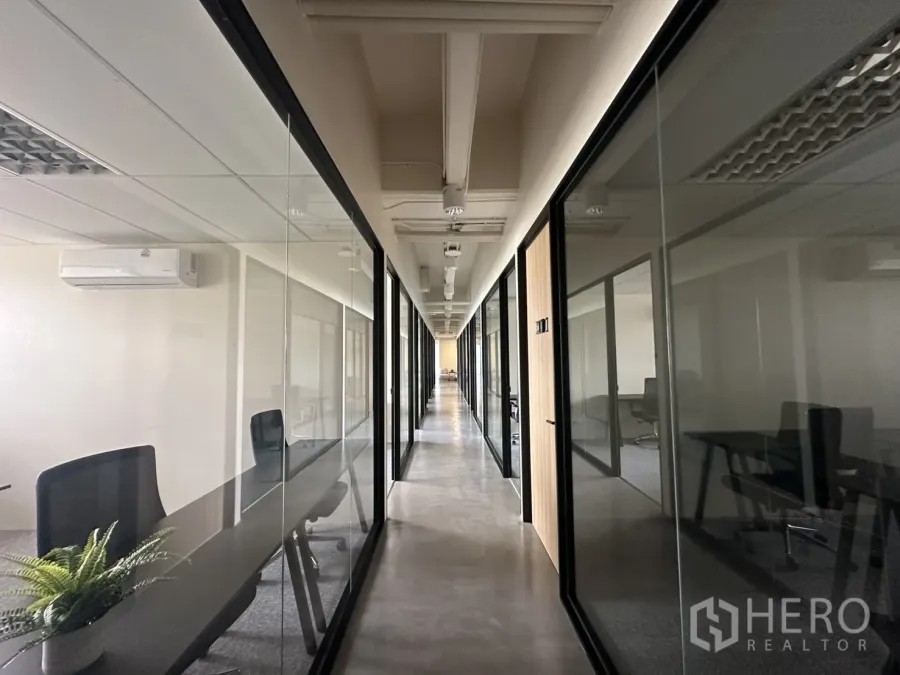 Office Space for rent in Bang Rak, Bangkok - Long corridor with glass-partitioned private offices and polished concrete floor.