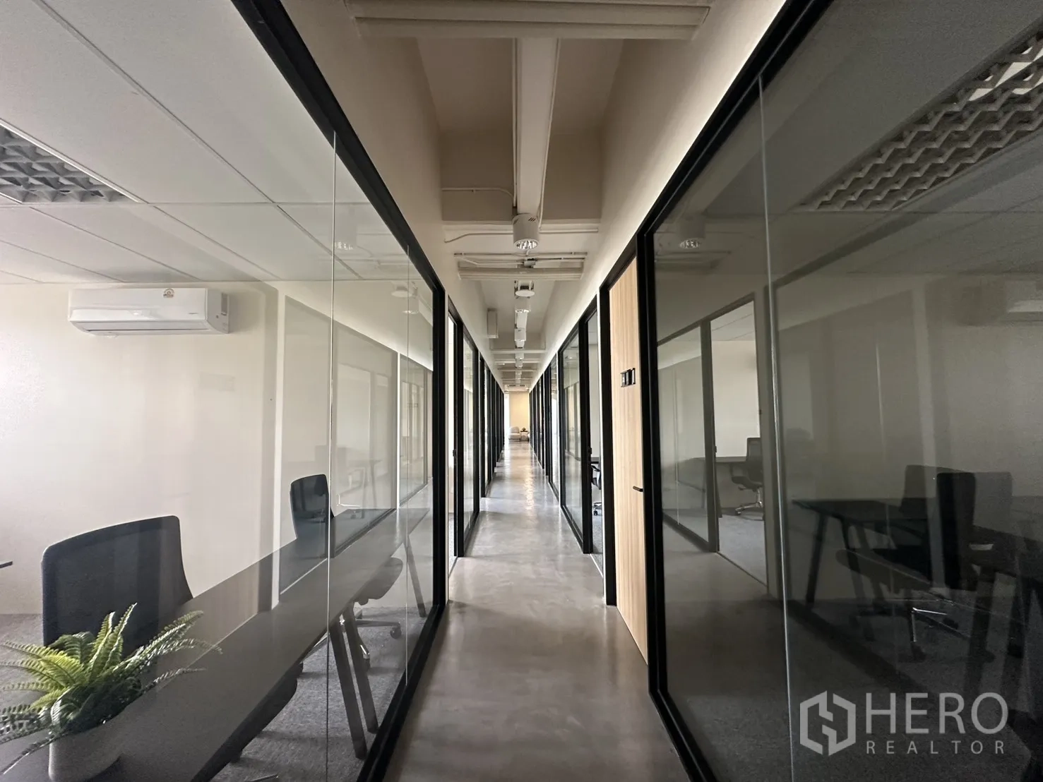 Office Space for rent in Bang Rak, Bangkok - Long corridor with glass-partitioned private offices and polished concrete floor.