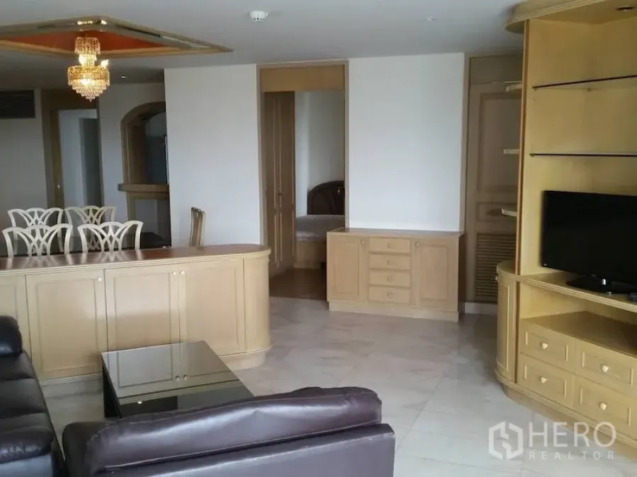 公寓 出租在Watthana, Bangkok - 宽敞客厅，皮沙发、内置电视柜与水晶吊灯，艾卡迈公寓。