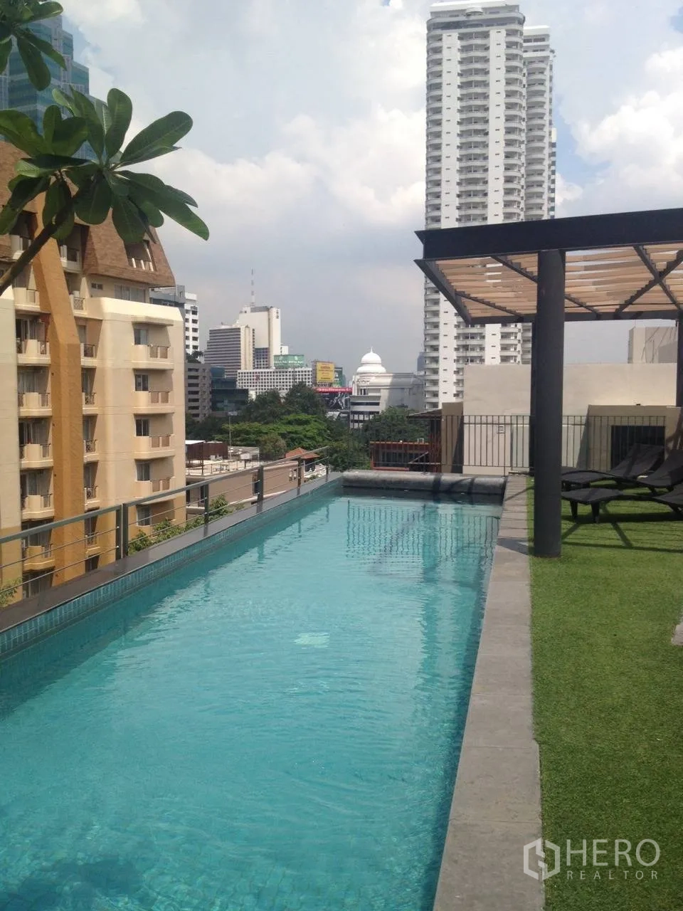 公寓 出租在Pathum Wan, Bangkok - 屋顶泳道池，城市天际线景观与日光躺椅区。