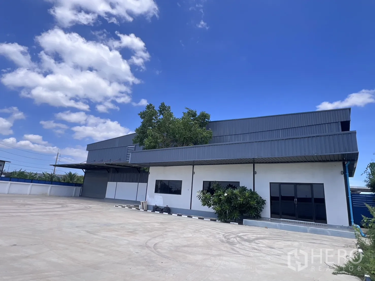 Warehouse for rent in Mueang Samut Sakhon, Samut Sakhon - Warehouse exterior with attached office block and large concrete yard.