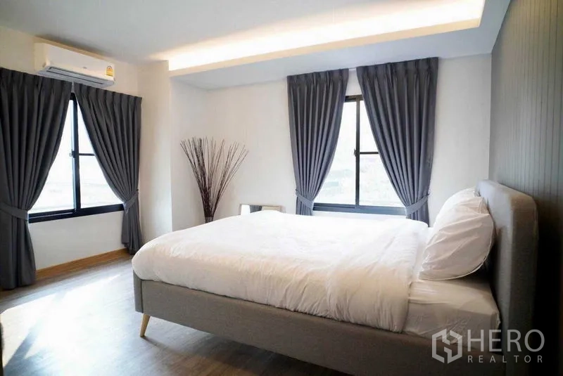 คอนโด ให้เช่าในWatthana, Bangkok - ห้องนอนรับแสง เตียงคู่ หน้าต่างมุมสองด้าน ผ้าม่านเข้ม และพื้นไม้