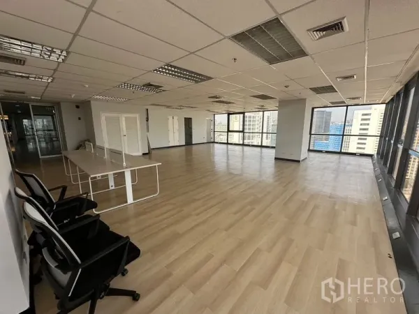 Office Space for rent in Bang Rak, Bangkok - Another angle of airy office space with expansive glazing and wood-style flooring.