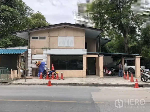 Retail Space for rent in Watthana, Bangkok - Front elevation of a two-storey retail property with wide display windows, covered entrance and sidewalk area.