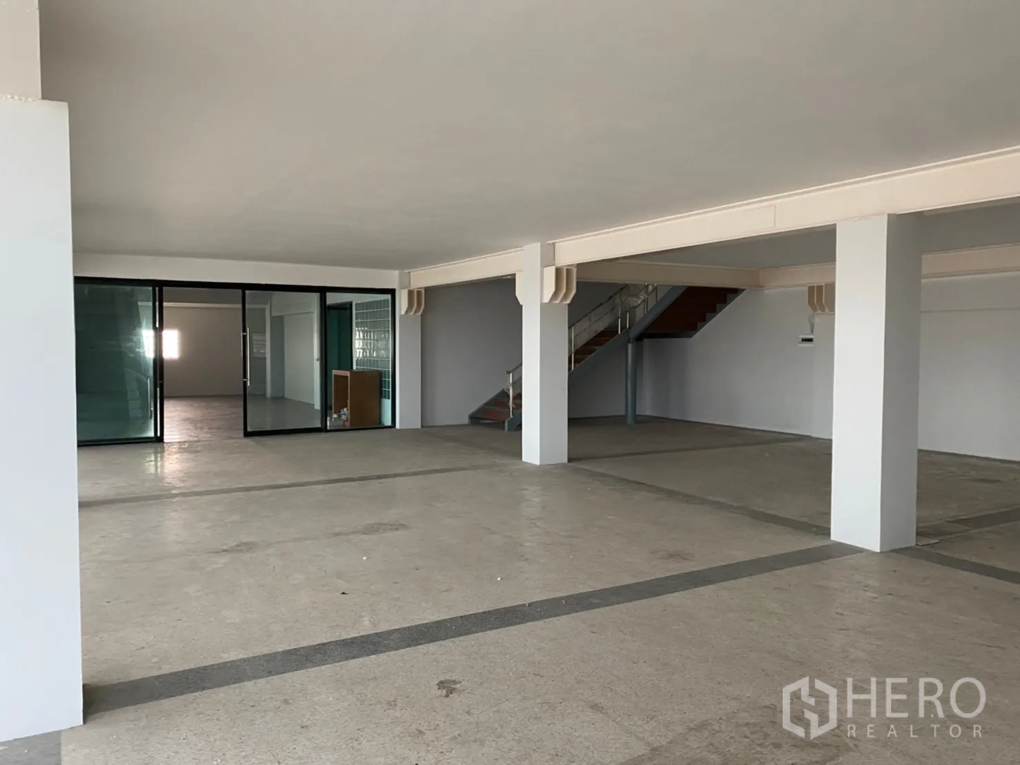 Warehouse for rent in Lat Krabang, Bangkok - Open-plan warehouse interior with glass-partitioned office and internal staircase.