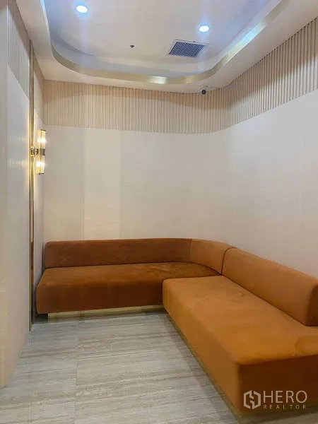 สำนักงาน ให้เช่าในHuai Khwang, Bangkok - โซนพักผ่อนพร้อมโซฟารูปตัวแอลสีส้ม ผนังลายไม้ และพื้นลายหิน